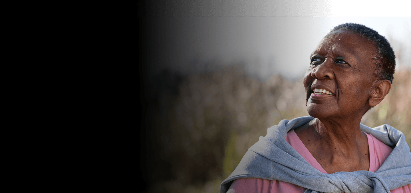 Elderly woman looking upward thoughtfully outdoors