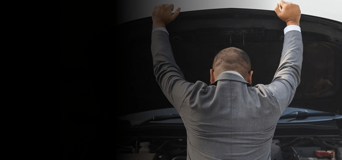 Man inspecting engine under an open car hood