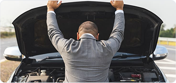 Man inspecting engine under car hood